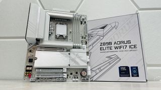 Gigabyte Z890 Aorus Elite WiFi 7 Ice on a light desk with a white background and SSD covers removed.