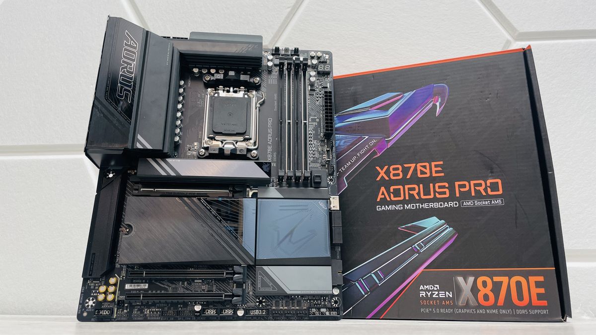 Gigabyte X870E Aorus Pro motherboard with the SSD heatsinks detached and on a light desk.